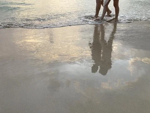 A strolling couple on the sunset beach Foto stock