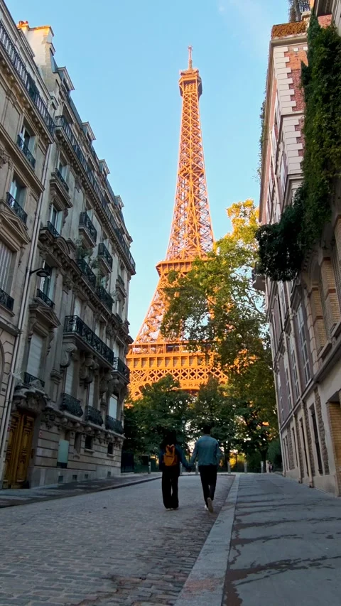 Strolling hand in hand under the warm glow of the Eiffel Tower in Paris Stock Footage 347503592