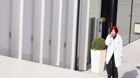 Strolling through the modern streets while chatting on the phone Vídeos de archivo 295273345