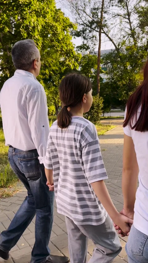 Strolling through the park, Holding hands tightly, A close family moment Stock Footage 313906412