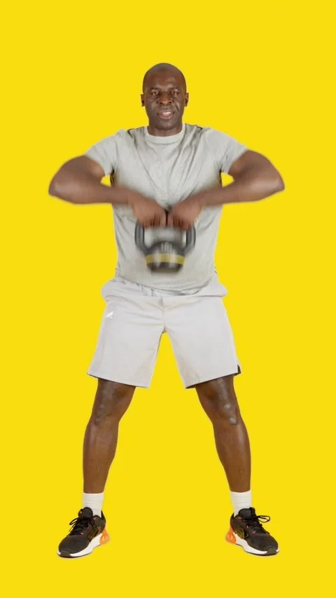 Strong african man doing rowing exercises with a kettlebell Stock Footage 242325097