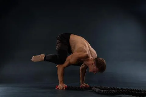 Strong athlete demonstrates advanced workout technique using battle ropes in a Stock Photos
