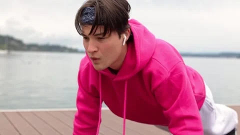 Strong athlete does push-ups near lake.Athlete fitness training push-ups nature Vidéo 259489273