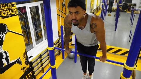 Strong athlete doing exercises on horizontal bar at modern gym. Muscular Stock Footage 313583376