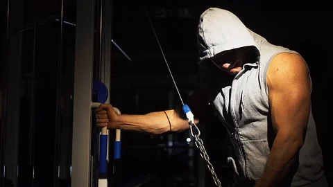 A strong athlete makes triceps exercises with a chain in a sports simulator. Stock Footage 87988238