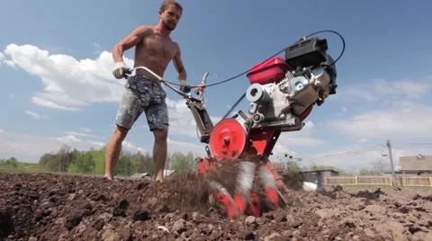 Strong athlete man working in the field with ripper cultivator Stock Footage 51536725
