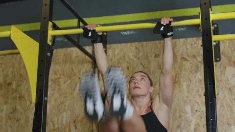 Strong athlete performs barbell pull-ups in a fitness gym to improve strength Stock Footage 331019549