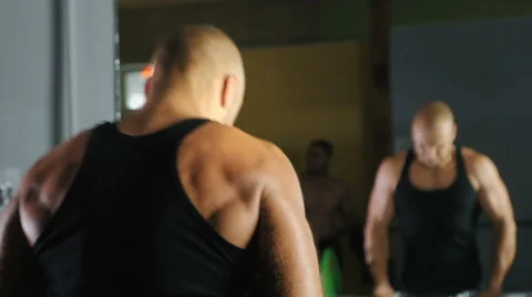 Strong athlete raises the bar in front of a mirror Stock Footage 66296781