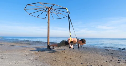 Strong athlete training on beach Stock Footage 122690496