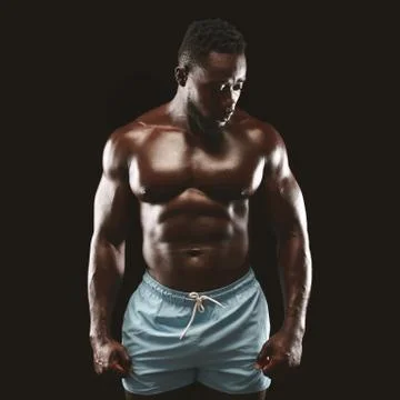 Strong athletic black man posing at studio, demonstrating muscular body Stock Photos