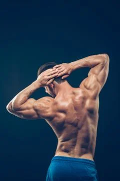 Strong athletic man back on dark background Stock Photos