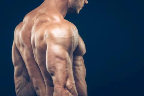 Strong athletic man back on dark background Stock Photos