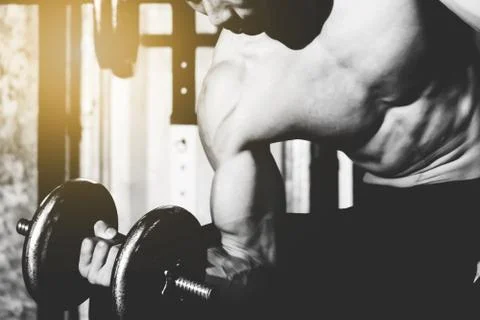 Strong athletic man Doing Exercises With Dumbbells in local gym Stock-Fotos