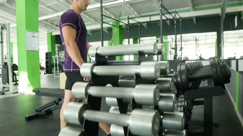 Strong athletic men taking heavy dumbbells for active workout in gym, fitness Stock Footage