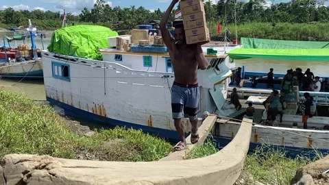 Strong Barefoot Worker Balancing Heavy Cargo Boxes on Narrow Plank Off Boat Stock Footage 318540811
