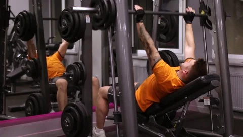 Strong bearded man doing bench press workout in gym Stock Footage 83128849