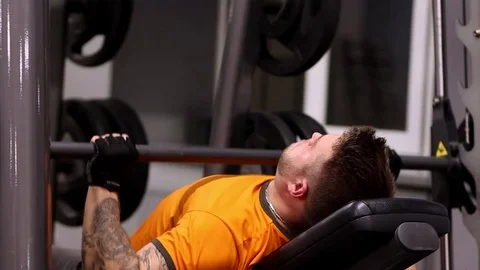 Strong bearded man doing bench press workout in gym Stock Footage 83128875