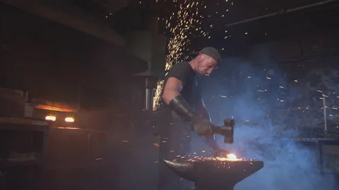 A strong blacksmith forges red-hot metal Видео 146580797