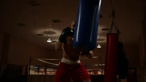 Strong blows to the pear in boxing gloves deal a strong man. Stock Footage 83914960