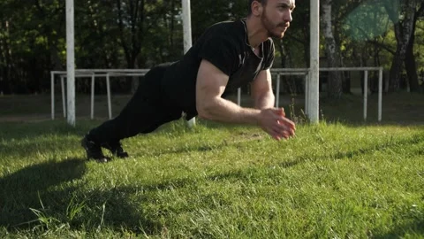 Strong bodybuilder with beard warms up, young athlete squeezes from the ground. 스톡 동영상 131392928