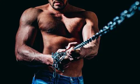 Strong bodybuilder with broken chains, perfect abs, shoulders, biceps, triceps Foto stock
