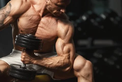 Strong bodybuilder doing exercise with dumbbell Stock-Fotos