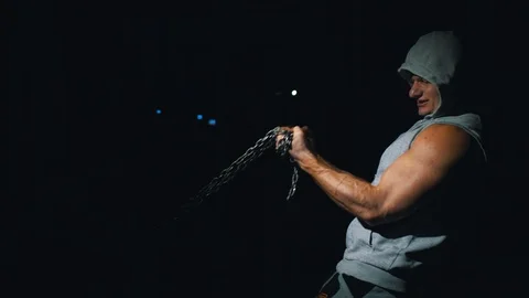 A strong bodybuilder makes biceps exercises with a chain in the gym. Stock Footage 88547991