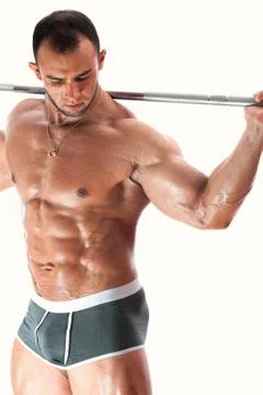 Strong bodybuilder posing shirtless with barbell Stock Photos
