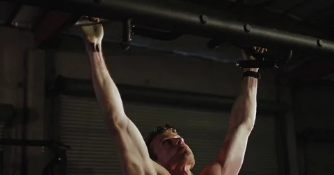 Strong caucasian man does pull-ups in a gym Stock Footage 83319519
