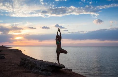 Strong confidence woman open arms under the  sunrise at seaside Stock Photos