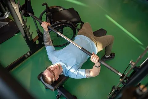 Strong dedicated serious disabled athletic man do sports, train upper body Stock Photos