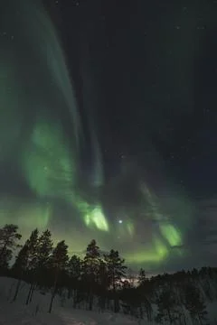 Strong explosion of green aurora borealis sweep across a star-speckled Arct.. 스톡 사진