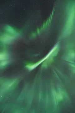 Strong explosion of green aurora borealis sweep across a star-speckled Arct.. 스톡 사진