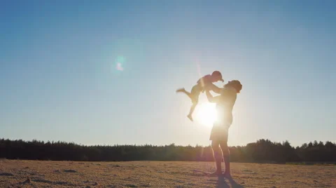 Strong father lobbed son in the sky. Playing with him at sunset Stock Footage 65764227