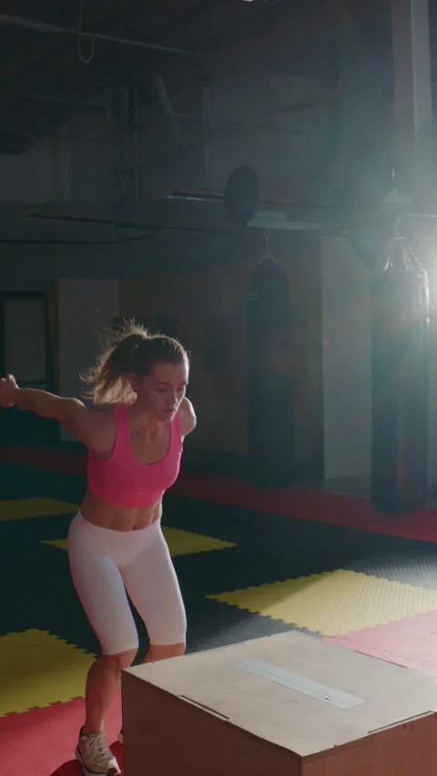 Strong female athlete executes explosive jump over box Stock Footage 335505466
