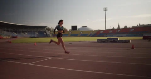 Strong female sprinter running fast during training against sunrise Video stock 243626048