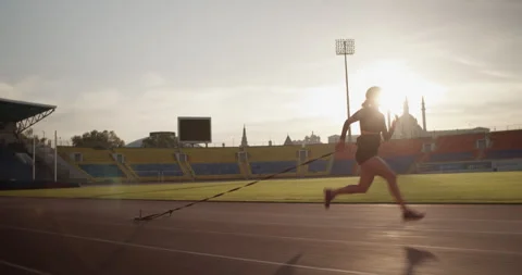 Strong female sprinter running with weights in stadium Video stock 243624867