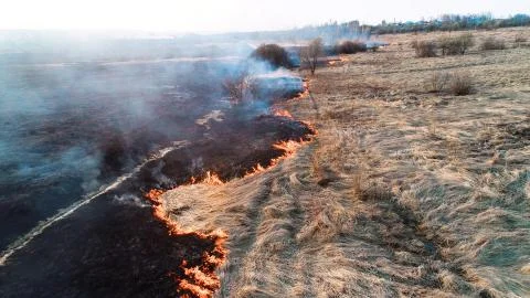 Strong fire in an empty field, strong smoke from a burning place. Flying over a Stock Photos