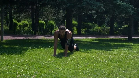 Strong fit athletic man training on the grass in the park Stock Footage 78926775