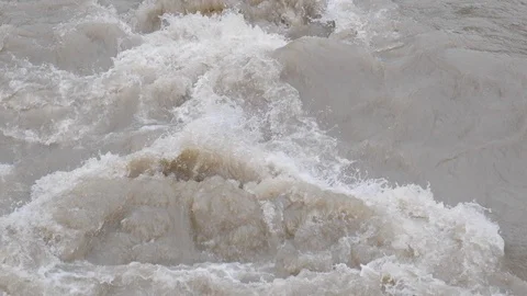 A strong flow of mountain rivers of dirty brown . Slow motion. A spray of water. Vidéo 108650202
