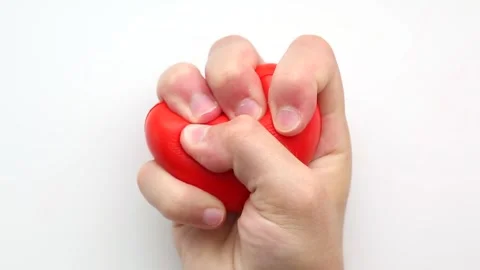Strong grip repeatedly deforms heart-shaped toy Stock Footage 315325377