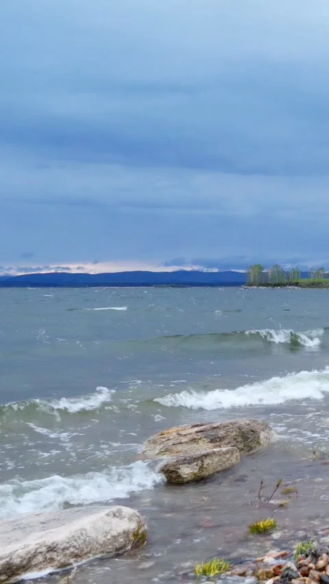 Strong gusts of wind and big waves on the shore of the lake. Stock Footage 293139109