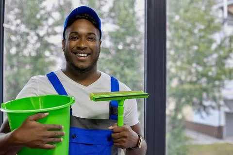 Strong guy cleaning worker came to fulfill the order for window laundering Stock Photos