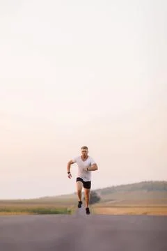 Strong guy running on road Stock Photos