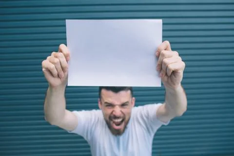 Strong guy is standing and screaming. He is yelling on camera. Man is holding Stock Photos