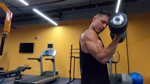 Strong guy workout his biceps with big dumbbell Video stock 138914693