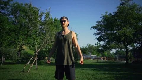 Strong healthy man do elbow warm up exercises sun green meadow rapid slow motion Video stock 78028671