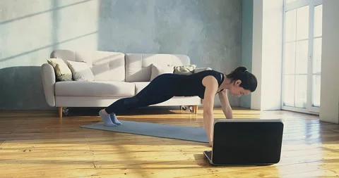 Strong lady does push ups watching video of training in room Stock-Footage 153802269