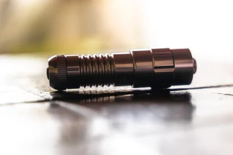 Strong laser pointer lying on a table Stock Photos