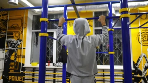 Strong male athlete doing pull ups on horizontal bar at modern gym. Sportsman Stock Footage 270485762